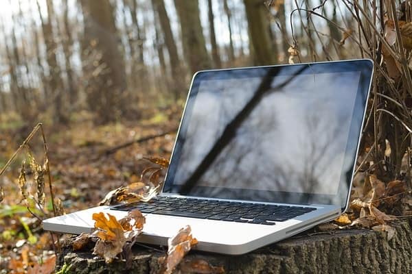 Laptop in the woods signifying being able to work with a semi-retire plan