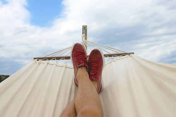 Person relaxing in hammock thinking about dollar financials