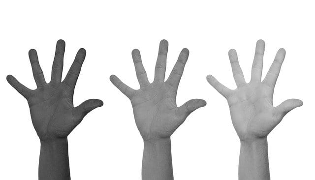 hands of difference races in the air to address racism