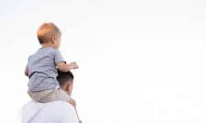 Dad with baby on shoulders living a debt free life