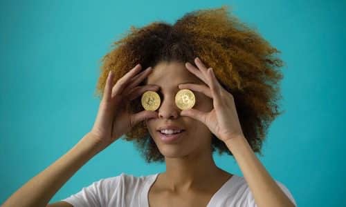 woman with two bitcoin over her eyes representing how to invest in bitcoin