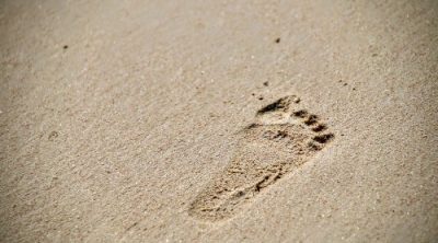 Footprint on a beach representing the Dave Ramsey Baby Steps