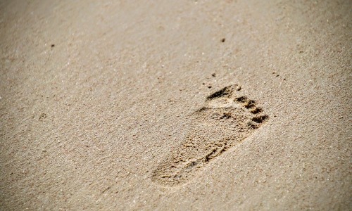 Footprint on a beach representing the Dave Ramsey Baby Steps