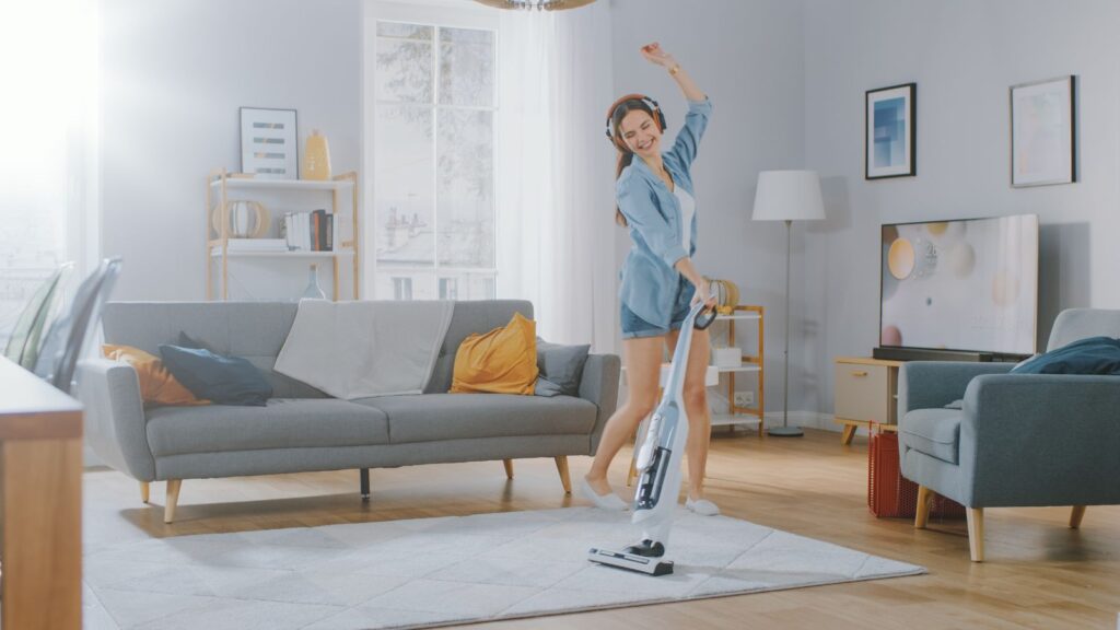 Young woman using her cordless vacuum. 