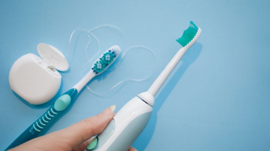 Electric toothbrush photos with regular toothbrush and floss