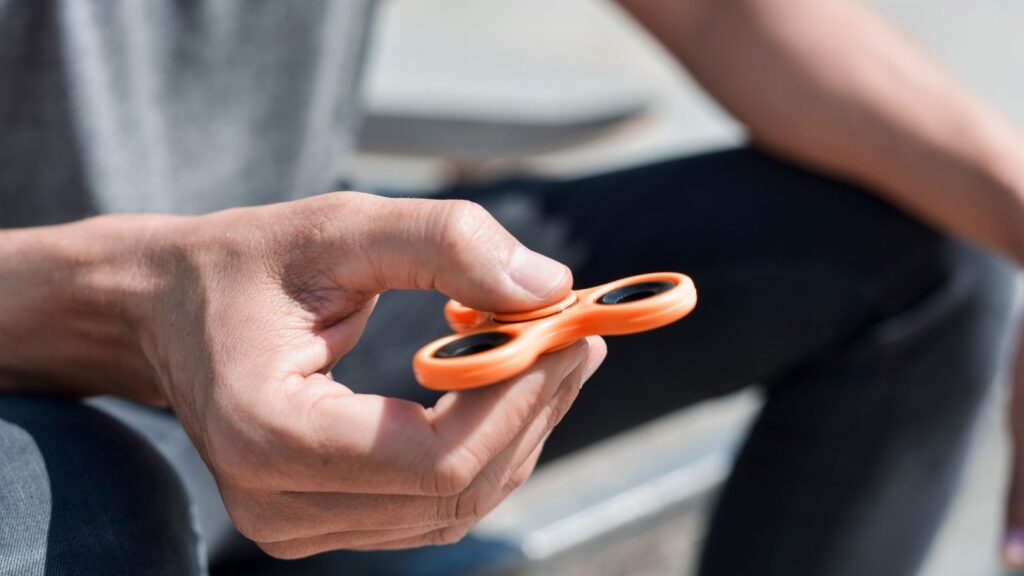 Photo of man with a fidget spinner. 