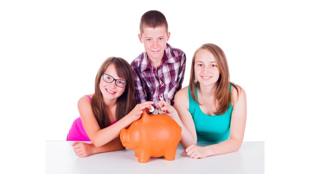 Three kids putting money in piggy bank