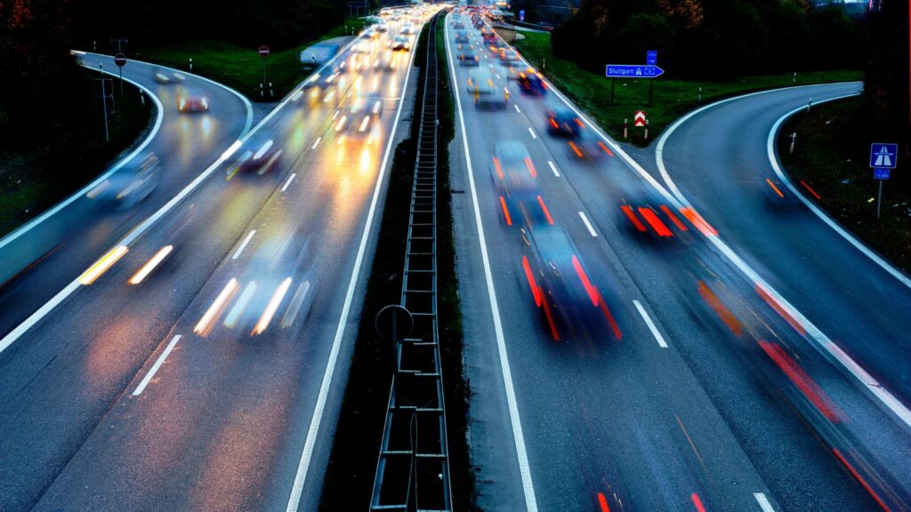 Cars speeding down the highway. 